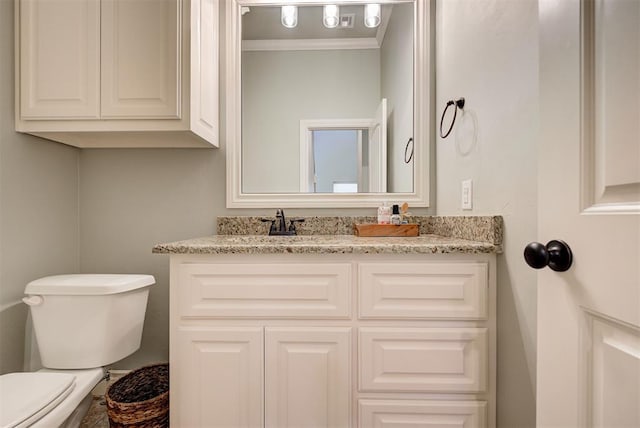 bathroom featuring ornamental molding, vanity, and toilet