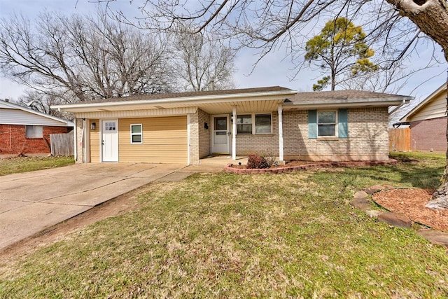 single story home with driveway, brick siding, and a front yard