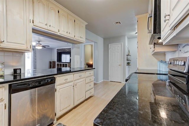 kitchen featuring visible vents, decorative backsplash, appliances with stainless steel finishes, dark stone countertops, and light wood-type flooring