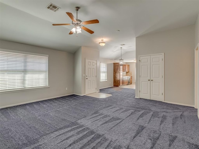 unfurnished living room with dark carpet, ceiling fan, and lofted ceiling