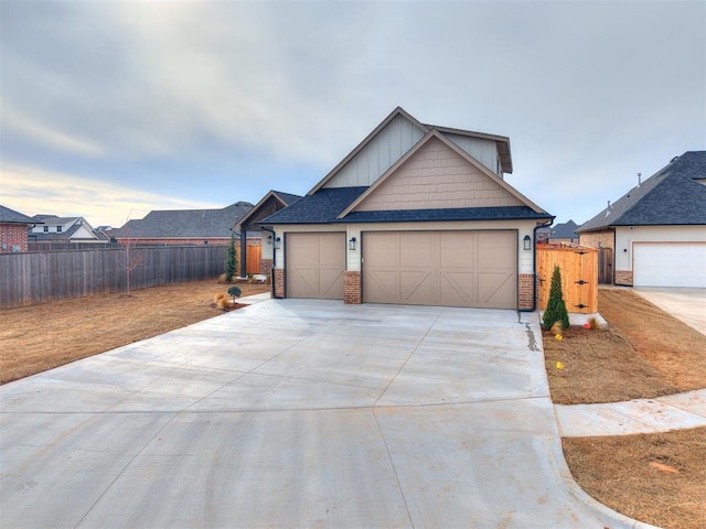 view of front of property with driveway, an attached garage, fence, and brick siding