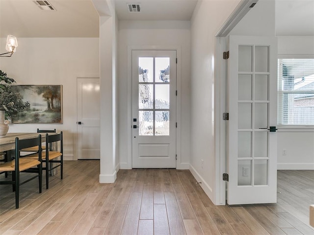 entryway with visible vents, light wood-style flooring, and baseboards