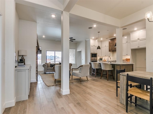 interior space with baseboards, light wood finished floors, a ceiling fan, and recessed lighting