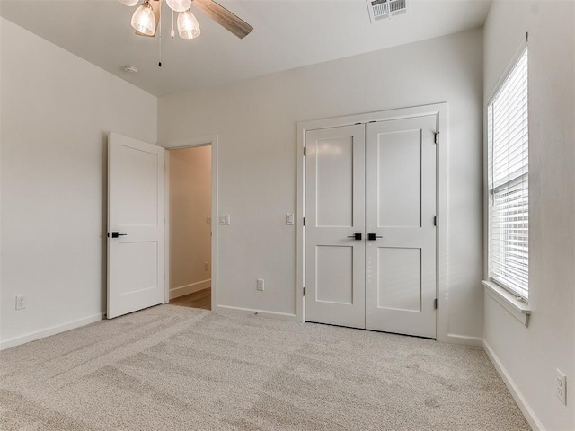 unfurnished bedroom with light carpet, multiple windows, and visible vents