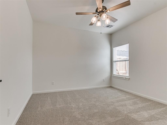 empty room featuring a ceiling fan, carpet flooring, visible vents, and baseboards