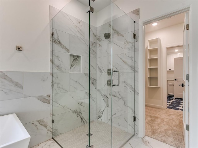 full bath with marble finish floor, a sink, and a shower stall