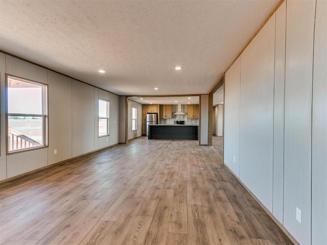 28992 Oakwood Meadows Dr, Cashion, OK 73016 - unfurnished living room featuring a textured ceiling and light hardwood / wood-style flooring