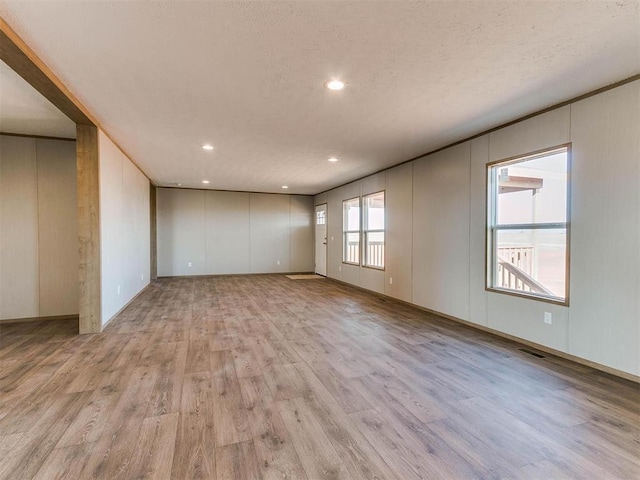 28992 Oakwood Meadows Dr, Cashion, OK 73016 - unfurnished room featuring a textured ceiling and light hardwood / wood-style floors