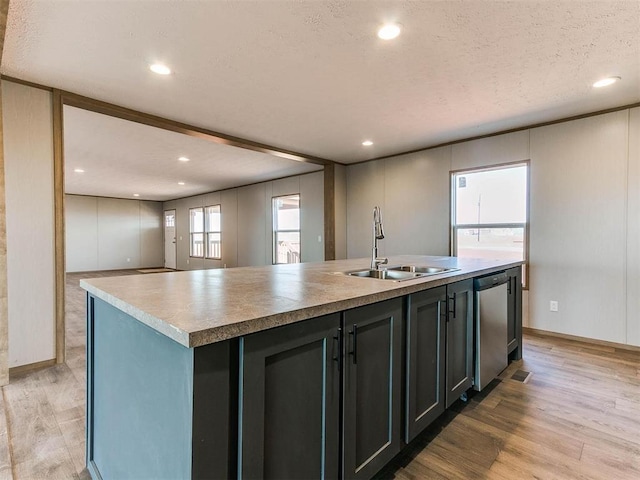 28992 Oakwood Meadows Dr, Cashion, OK 73016 - kitchen with sink, a textured ceiling, stainless steel dishwasher, a center island with sink, and light hardwood / wood-style flooring