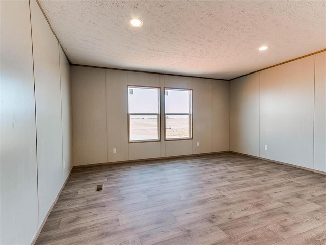 28992 Oakwood Meadows Dr, Cashion, OK 73016 - empty room with a textured ceiling and light hardwood / wood-style flooring
