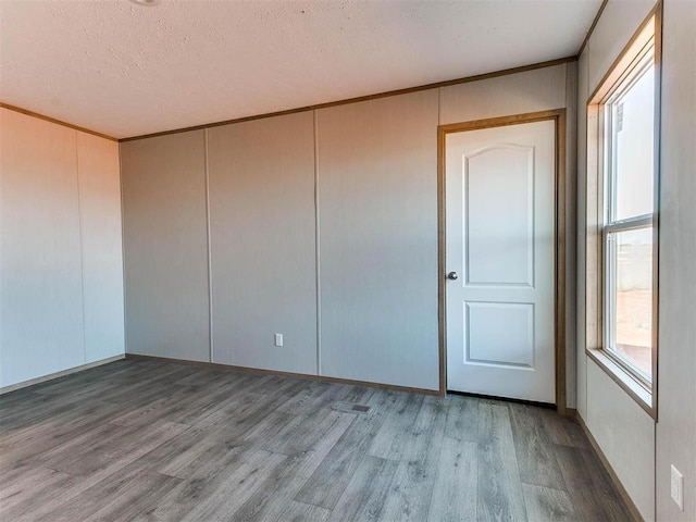 28992 Oakwood Meadows Dr, Cashion, OK 73016 - unfurnished bedroom with a closet, a textured ceiling, and hardwood / wood-style flooring