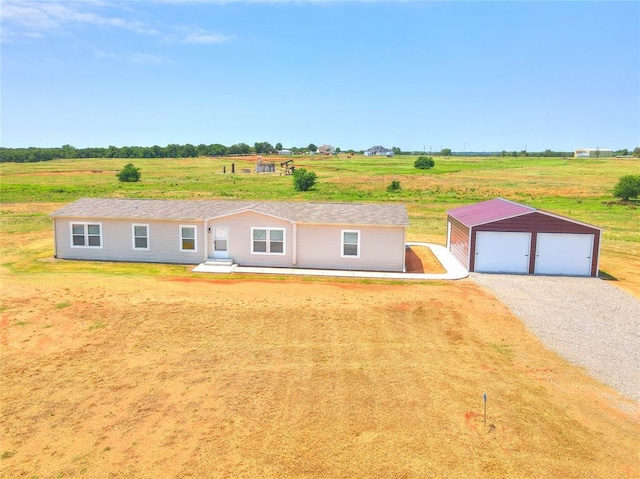 single story home with an outbuilding, a detached garage, and a rural view