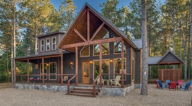 rear view of house featuring an outdoor fire pit and metal roof