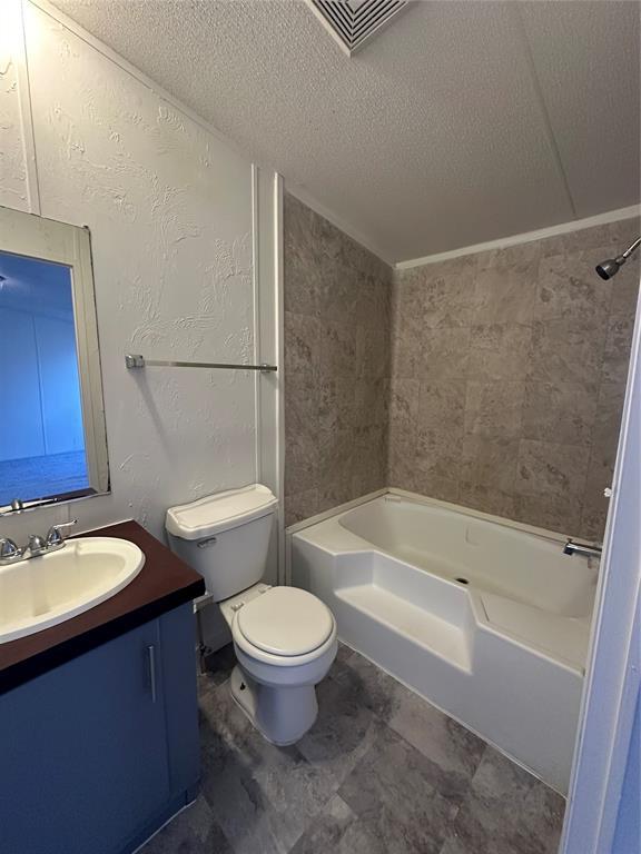 full bathroom with toilet, visible vents, tub / shower combination, and a textured ceiling