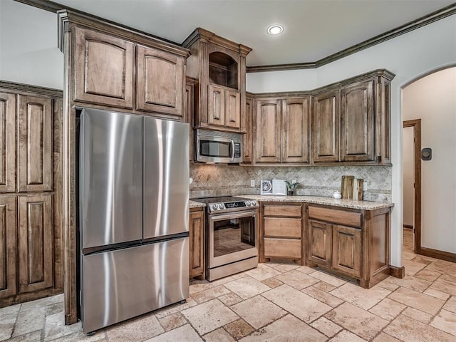 8275 Elk Grv, Blanchard, OK 73010 - kitchen with stainless steel appliances, arched walkways, backsplash, stone tile floors, and crown molding