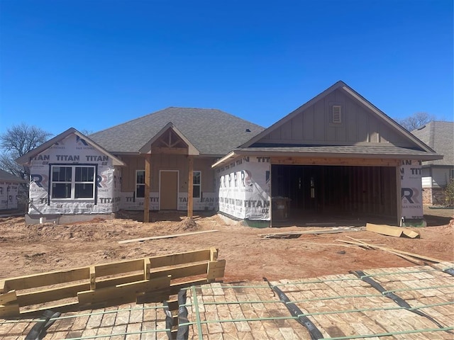 unfinished property with roof with shingles, decorative driveway, board and batten siding, and an attached garage