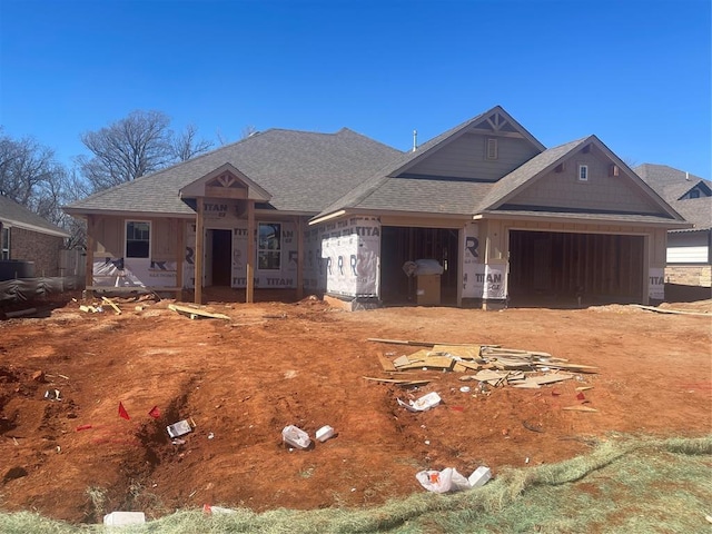 property under construction featuring a shingled roof and an attached garage