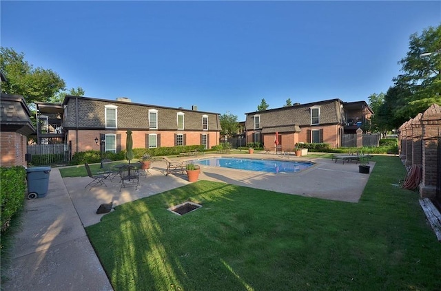 view of pool featuring a patio area, fence, a fenced in pool, and a yard