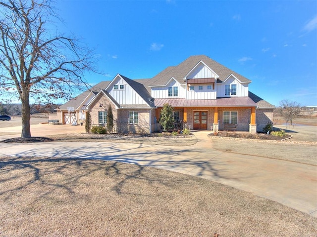 view of front of home featuring brick siding, a shingled roof, board and batten siding, a standing seam roof, and metal roof