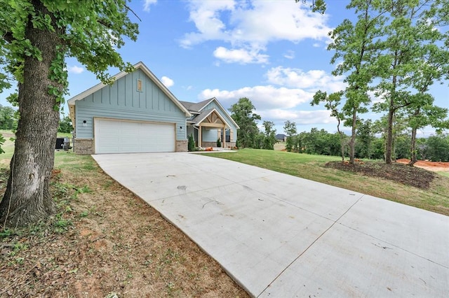 10949 Sandstone Ridge Way, Guthrie, OK 73044 - view of front of house featuring board and batten siding, driveway, an attached garage, and a front yard