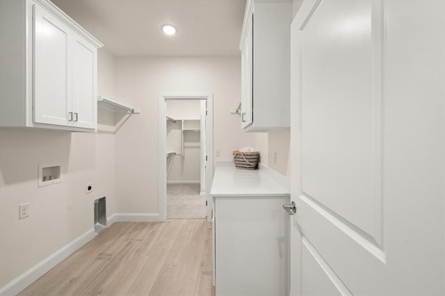 10949 Sandstone Ridge Way, Guthrie, OK 73044 - washroom with electric dryer hookup, light wood-style flooring, cabinet space, washer hookup, and baseboards