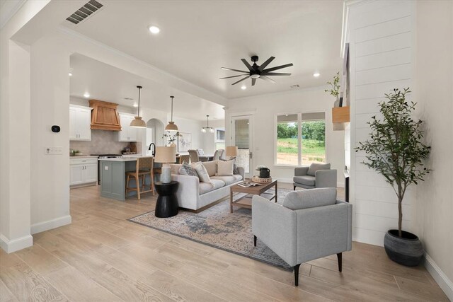 10949 Sandstone Ridge Way, Guthrie, OK 73044 - living room featuring ceiling fan, light wood-style flooring, baseboards, recessed lighting, and crown molding