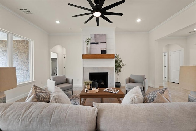 10949 Sandstone Ridge Way, Guthrie, OK 73044 - living area featuring arched walkways, a ceiling fan, wood finished floors, a fireplace, and baseboards