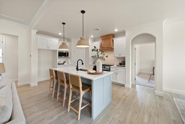 10949 Sandstone Ridge Way, Guthrie, OK 73044 - kitchen featuring ornamental molding, recessed lighting, tasteful backsplash, light countertops, and light wood-type flooring