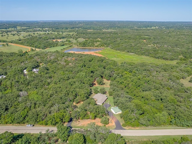 bird's eye view with a water view and a wooded view