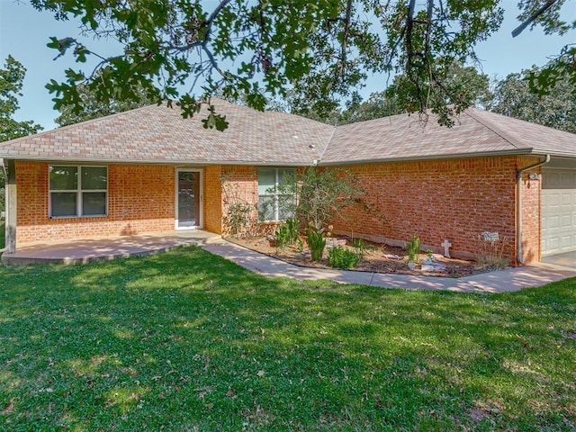 ranch-style home with a garage, brick siding, and a front yard