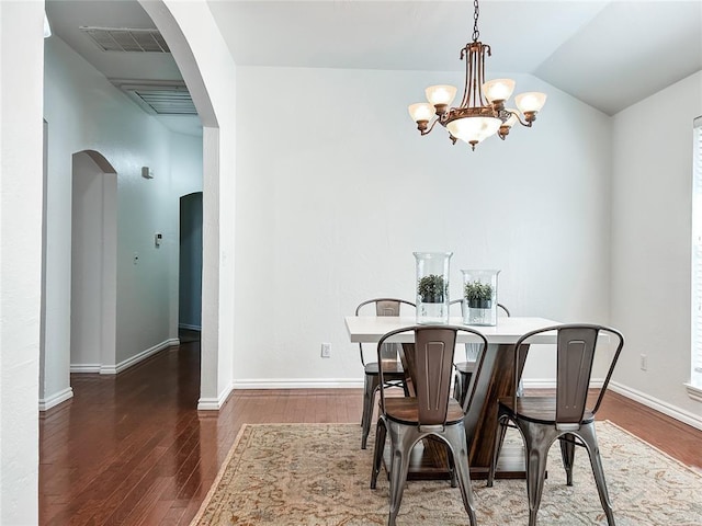 dining room featuring visible vents, arched walkways, and wood finished floors