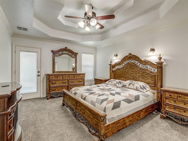 bedroom featuring visible vents, a raised ceiling, ceiling fan, ornamental molding, and carpet