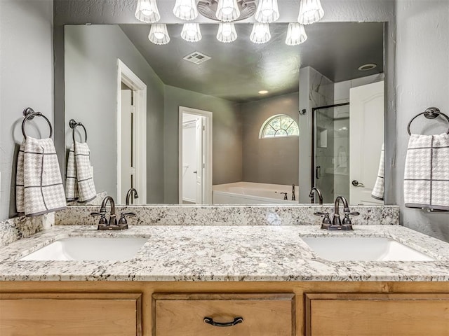 bathroom featuring a stall shower, visible vents, a garden tub, and vanity