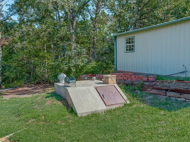 entry to storm shelter featuring a yard