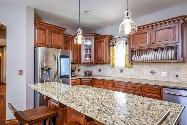 kitchen featuring arched walkways, backsplash, appliances with stainless steel finishes, and glass insert cabinets