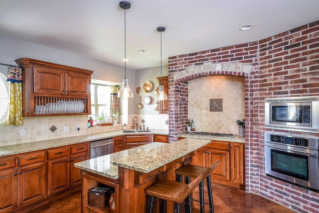 kitchen with decorative light fixtures, a kitchen island, appliances with stainless steel finishes, decorative backsplash, and light stone countertops