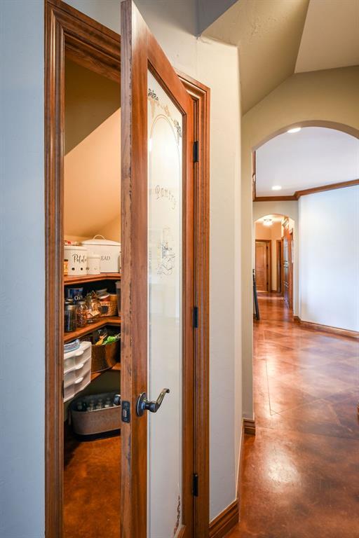 corridor with arched walkways and baseboards