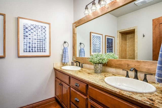 full bathroom featuring a sink, visible vents, baseboards, and double vanity