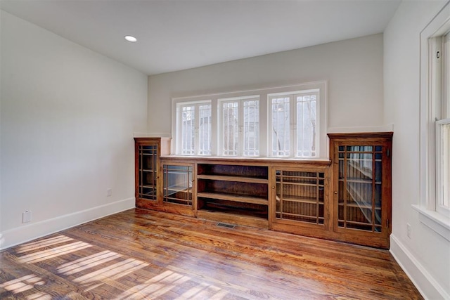 empty room featuring visible vents, baseboards, recessed lighting, and wood finished floors