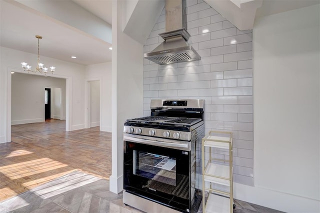 kitchen featuring stainless steel range with gas cooktop, tasteful backsplash, wall chimney range hood, a chandelier, and wood finished floors