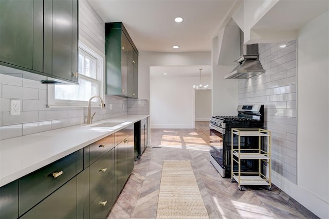 kitchen with stainless steel range with gas stovetop, a chandelier, a sink, decorative backsplash, and green cabinetry