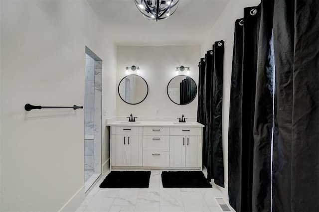 bathroom with a sink, walk in shower, double vanity, and marble finish floor