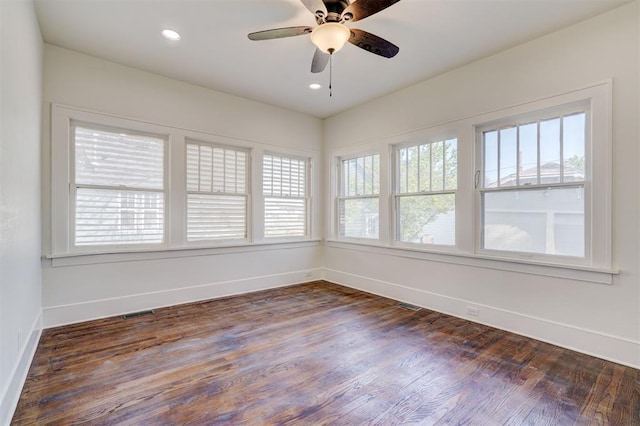 unfurnished room featuring plenty of natural light and dark wood-type flooring