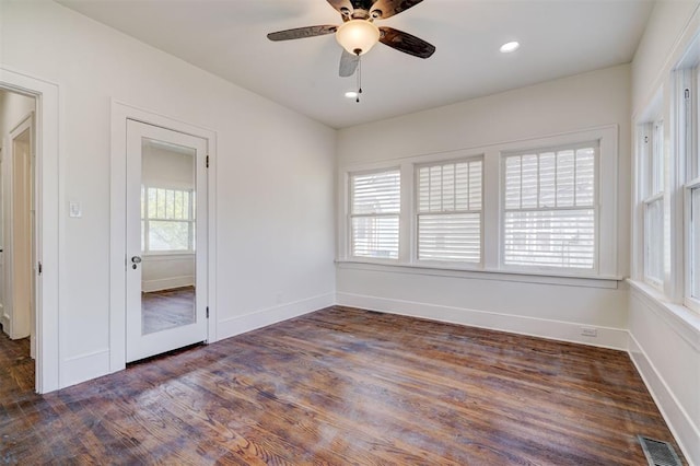 empty room featuring visible vents, baseboards, a ceiling fan, and wood finished floors