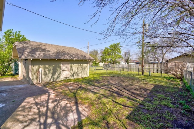 view of yard featuring fence and an outbuilding
