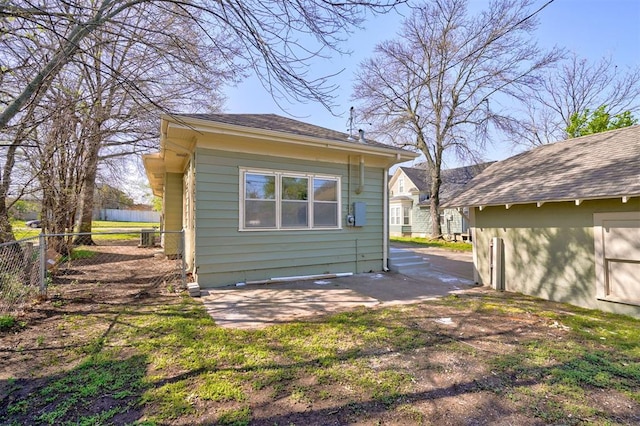 view of side of home with a patio area and fence