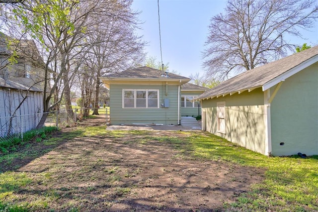 back of property with fence and stucco siding