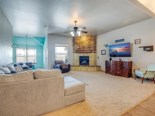 carpeted living room featuring tile patterned floors, a large fireplace, visible vents, and ceiling fan with notable chandelier