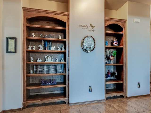 bar featuring baseboards, built in features, and tile patterned floors