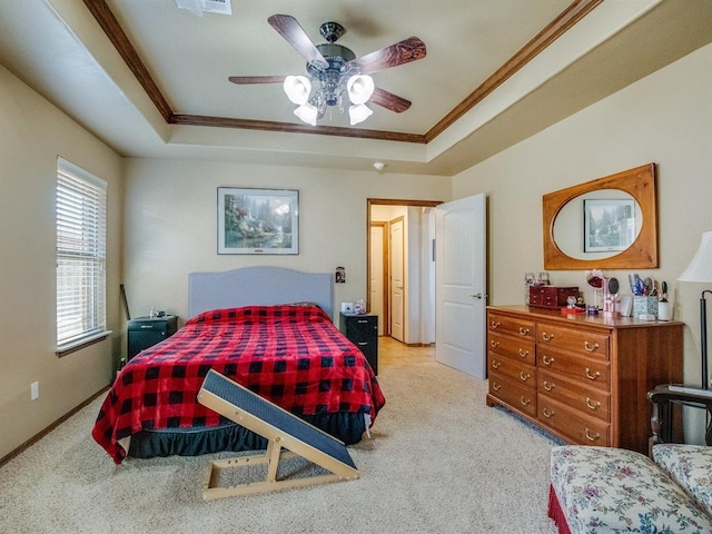 bedroom featuring light carpet, baseboards, a raised ceiling, and crown molding